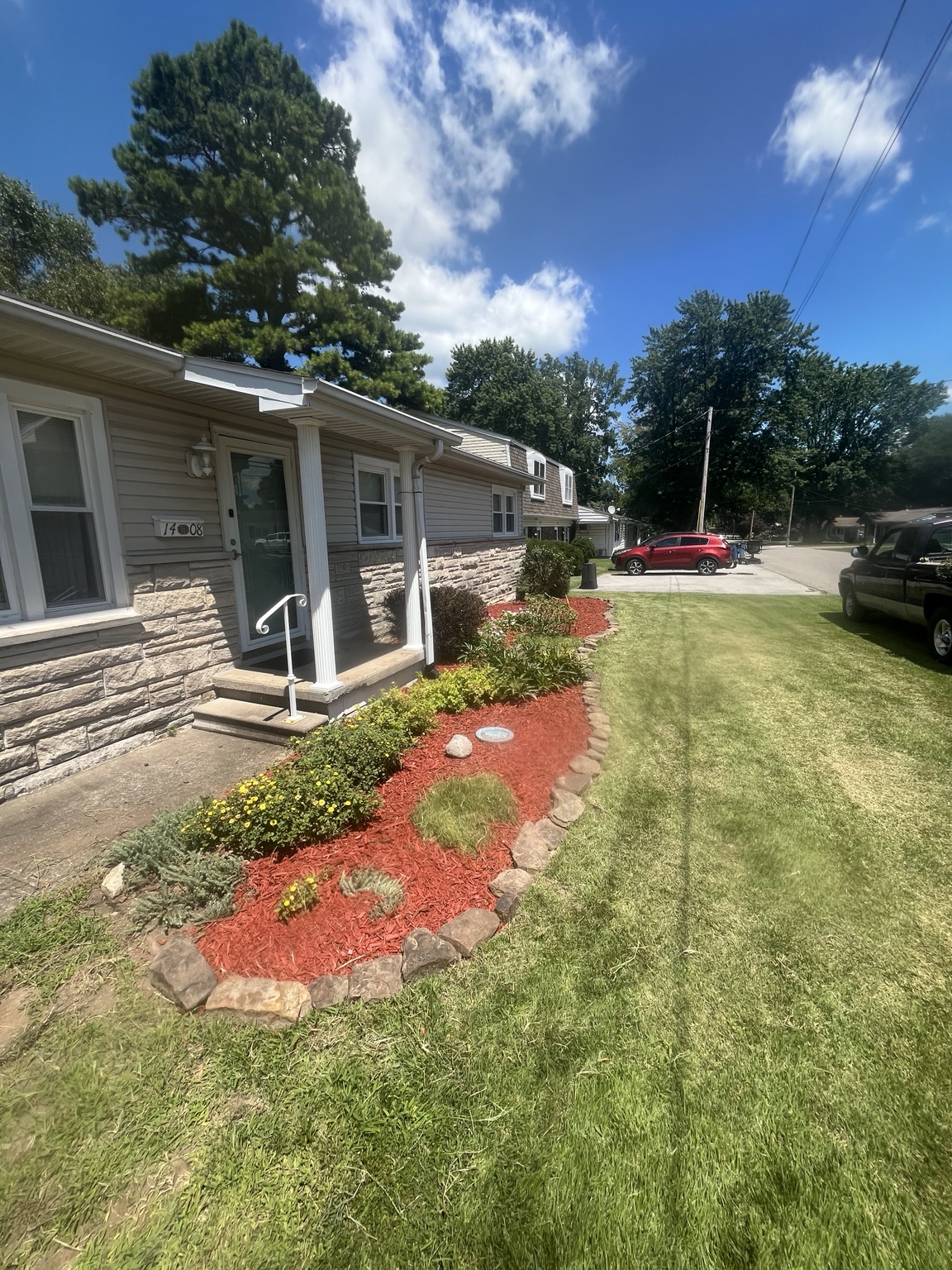 Red mulch landscape bed with plants